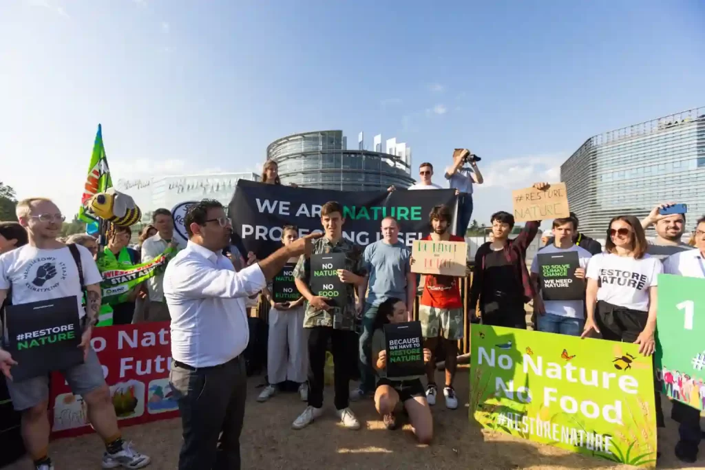 Advocates of the Nature Restoration Law who are concerned about climate change gather in front of the European Parliament.